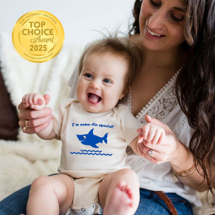 Baby wearing a onesie with a shark design, sitting on a woman's lap with a 'Top Choice Award 2025' badge.