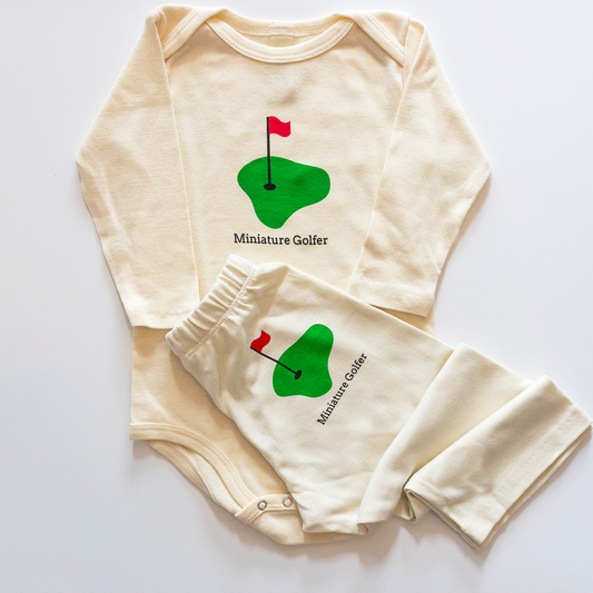 Baby onesie and pants set with golf design on a white background
