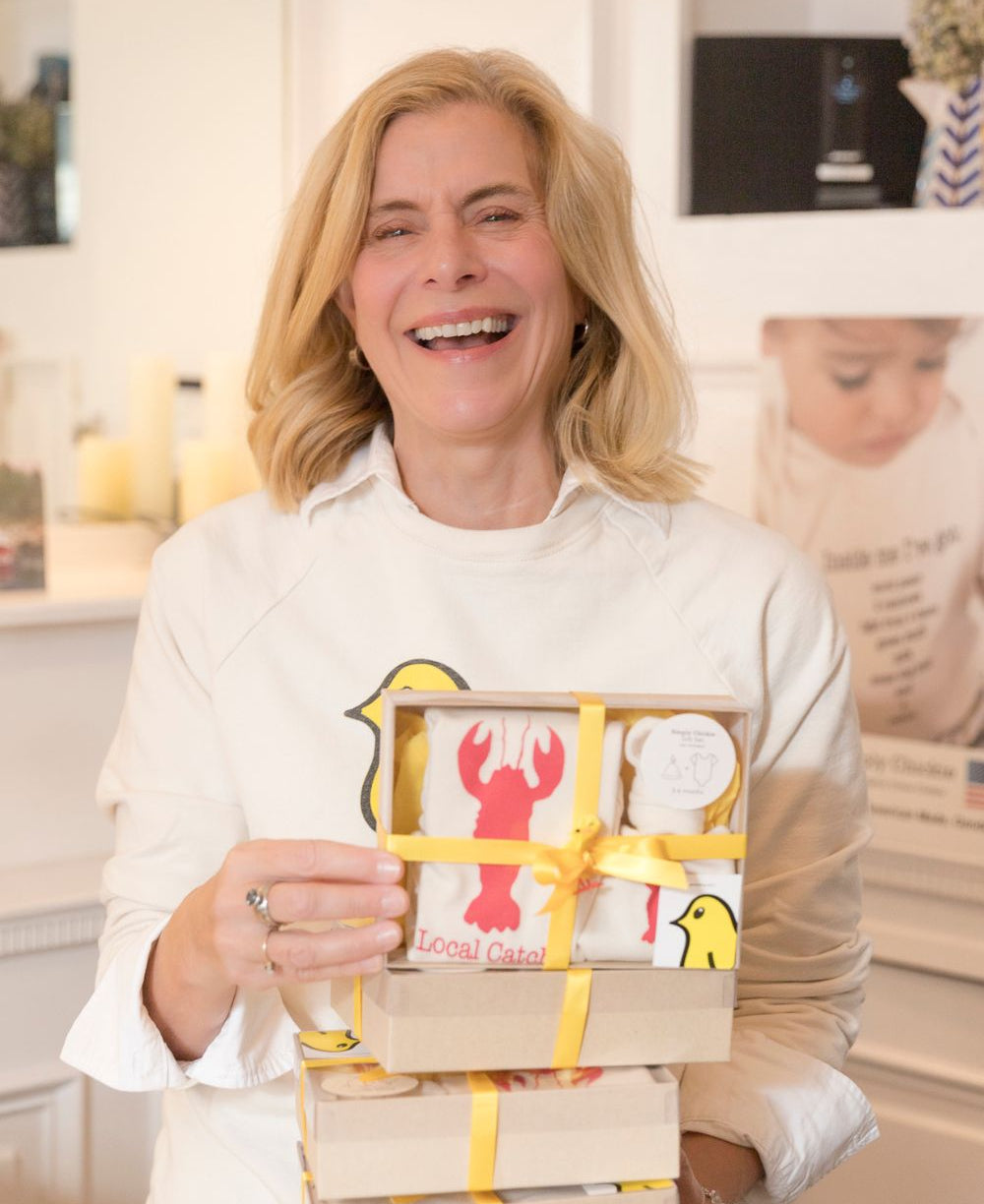 Woman holding a gift box with a lobster design in a kitchen setting